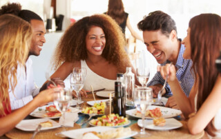 The Best Restaurants off of Taylor Bay Beach: A group of friends enjoying a meal together